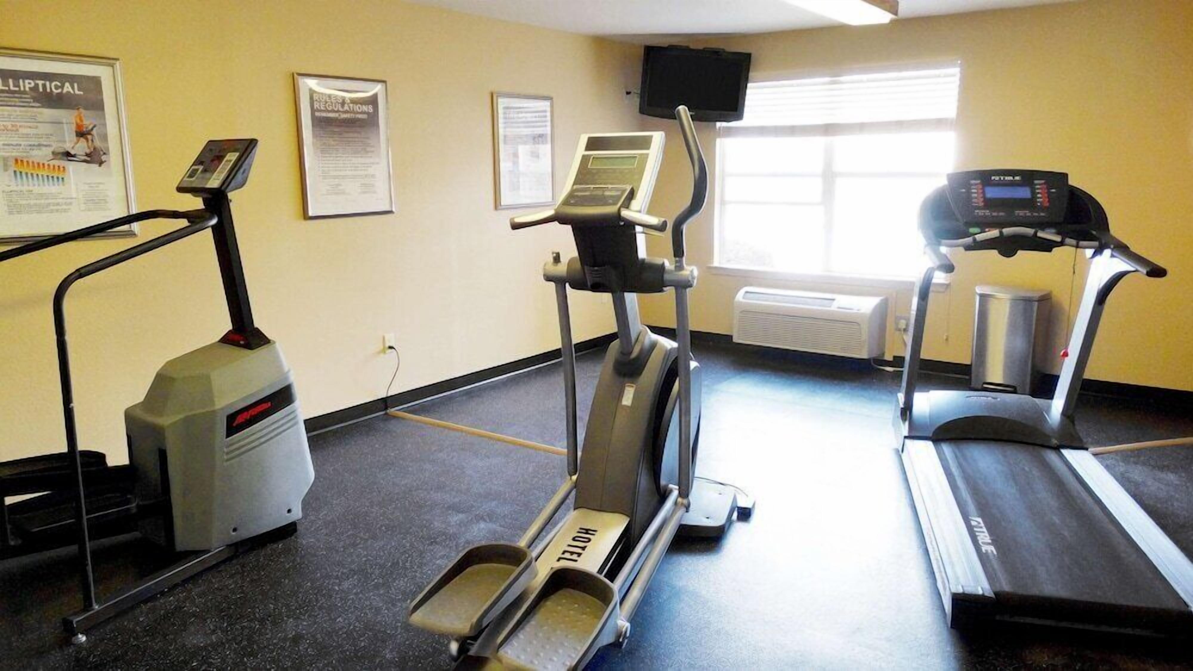 A gym with treadmills, elliptical machines, and a stationary bike.
