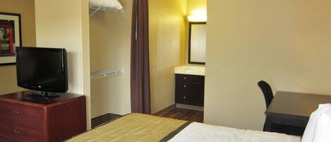 Escritorio, cortinas blackout y tabla de planchar con plancha