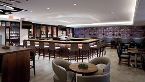 Un espace bar moderne avec un bar central, des sièges disposés autour, et un panneau de sortie bien visible.
