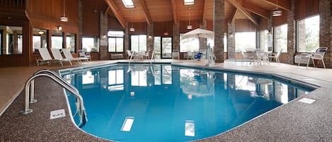 Una piscina techada, sillones reclinables de piscina