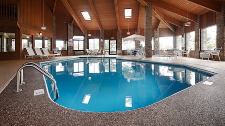 Una piscina techada, sillones reclinables de piscina