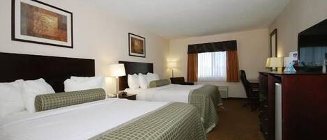 Una habitación de hotel con dos camas, un escritorio, una silla y un televisor.