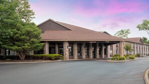 A building with a covered entrance, brick columns, and a sign indicating a room number. - Baymont by Wyndham Delaware (Delaware)