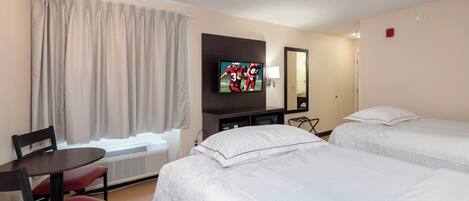 A hotel room with two beds, a TV, a desk, and a chair.