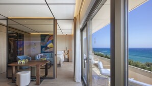 A modern hotel room with a balcony, a wooden floor, a dining area, and a view of the ocean. - Four Seasons Hotel (Limassol)