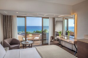 A hotel room with a bed, a desk, a chair, and a balcony with a view of the sea. - Four Seasons Hotel (Limassol)