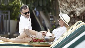 Couples can unwind on a sun lounger on the deck, surrounded by lush trees.