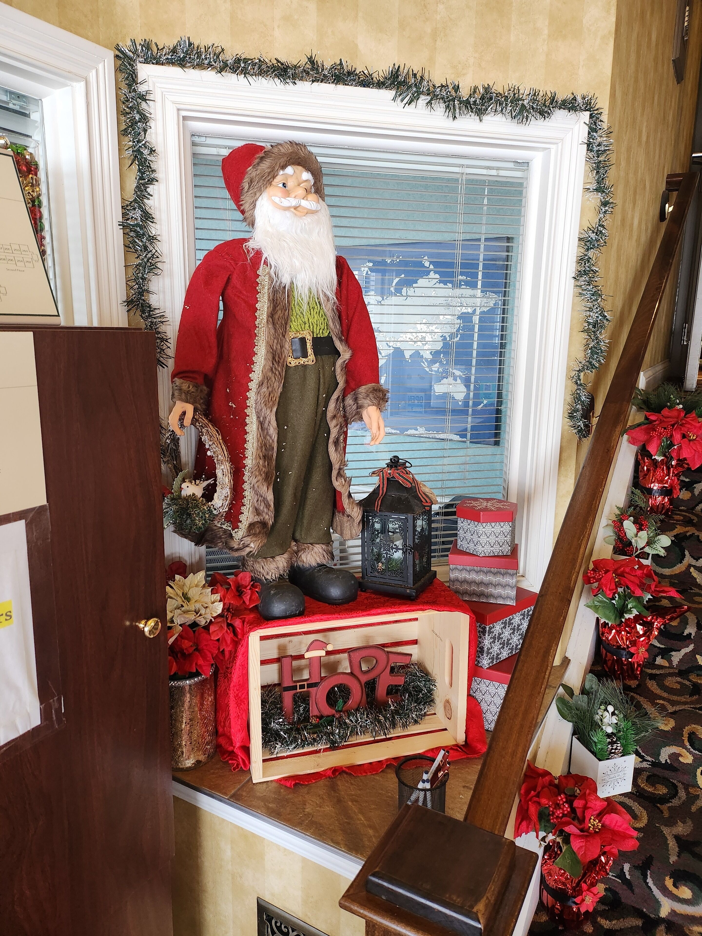 Decoración navideña con una figura de Papá Noel, un cartel que dice 'HOPE' y adornos festivos.