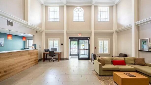 A spacious lobby with a reception desk, seating area, and a staircase leading to upper floors. - Sleep Inn & Suites Birmingham - Hoover (Birmingham)