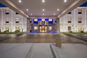 A hotel entrance with a stone facade, a blue-lit entrance, and a sign reading "Comfort Inn." - Comfort Inn & Suites River City Decatur (Decatur)