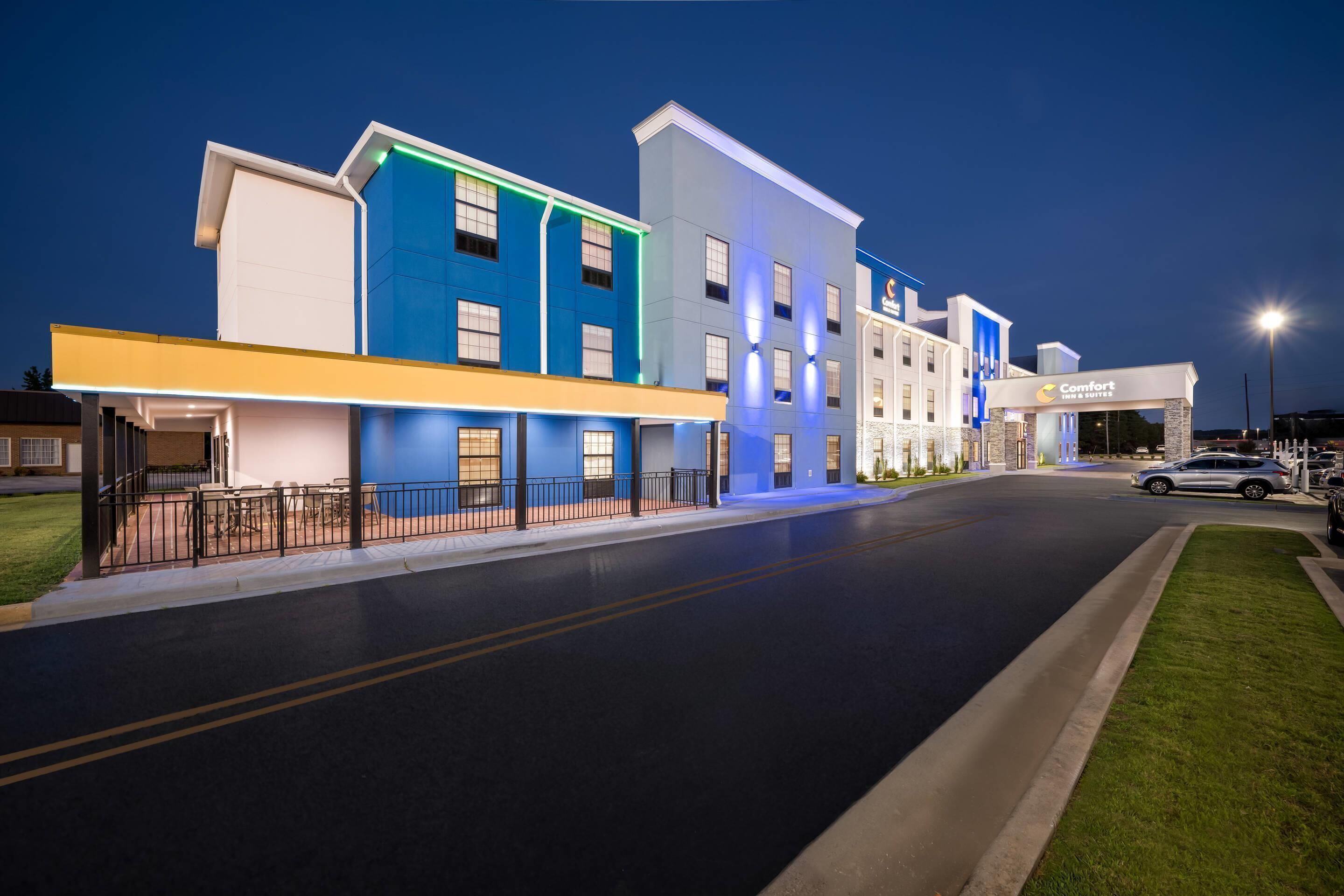 A hotel with a modern design, featuring a flat roof, multiple windows, and a well-lit entrance.