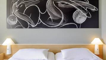 Una habitación de hotel con una cama, dos lámparas de noche y una obra de arte abstracta grande en la pared.