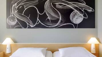 A hotel room with a large abstract artwork on the wall, two beds with white linens, and two bedside lamps.