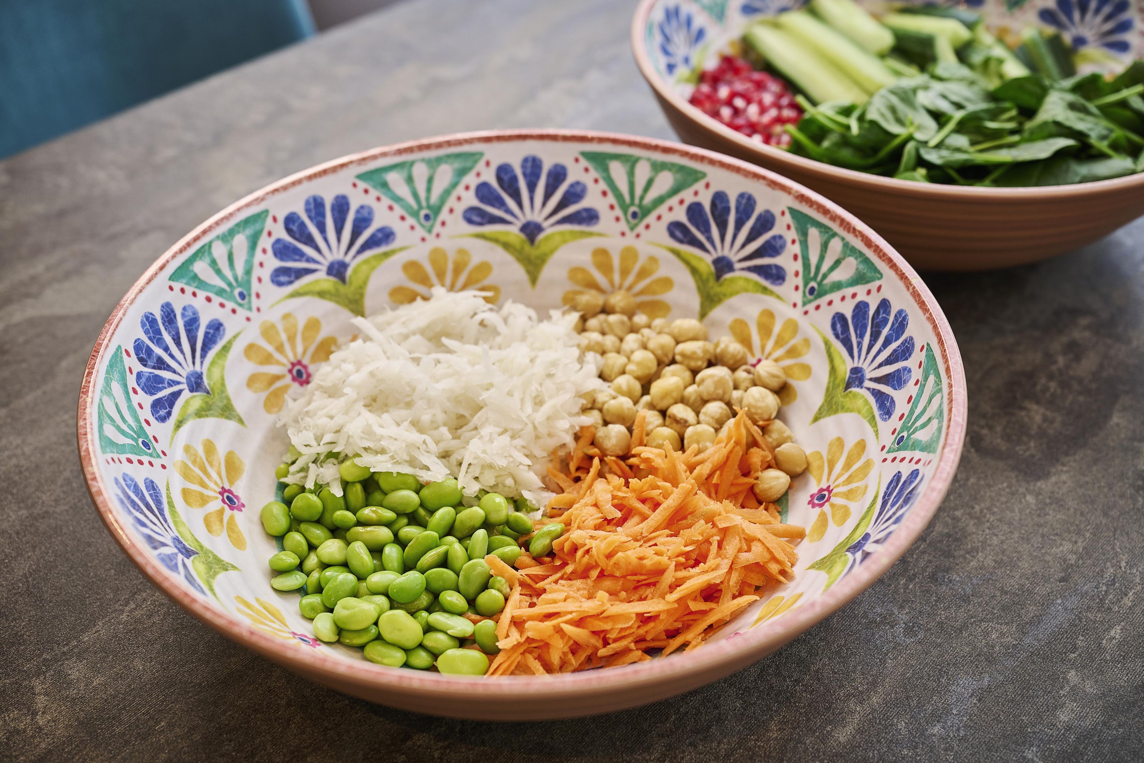 Un plato con zanahorias ralladas, edamame y arroz blanco.