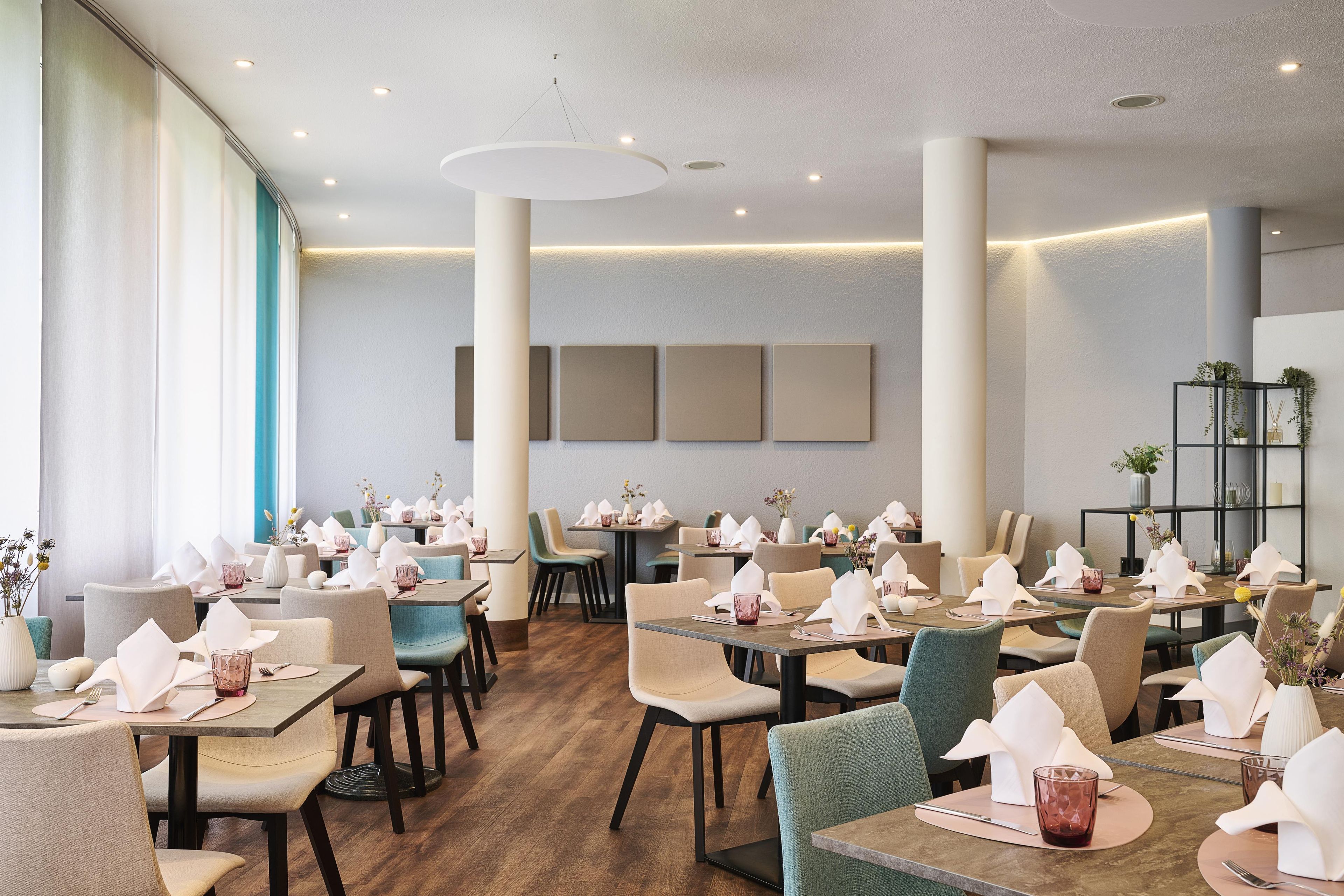 A restaurant with multiple tables, chairs, and a modern interior design.