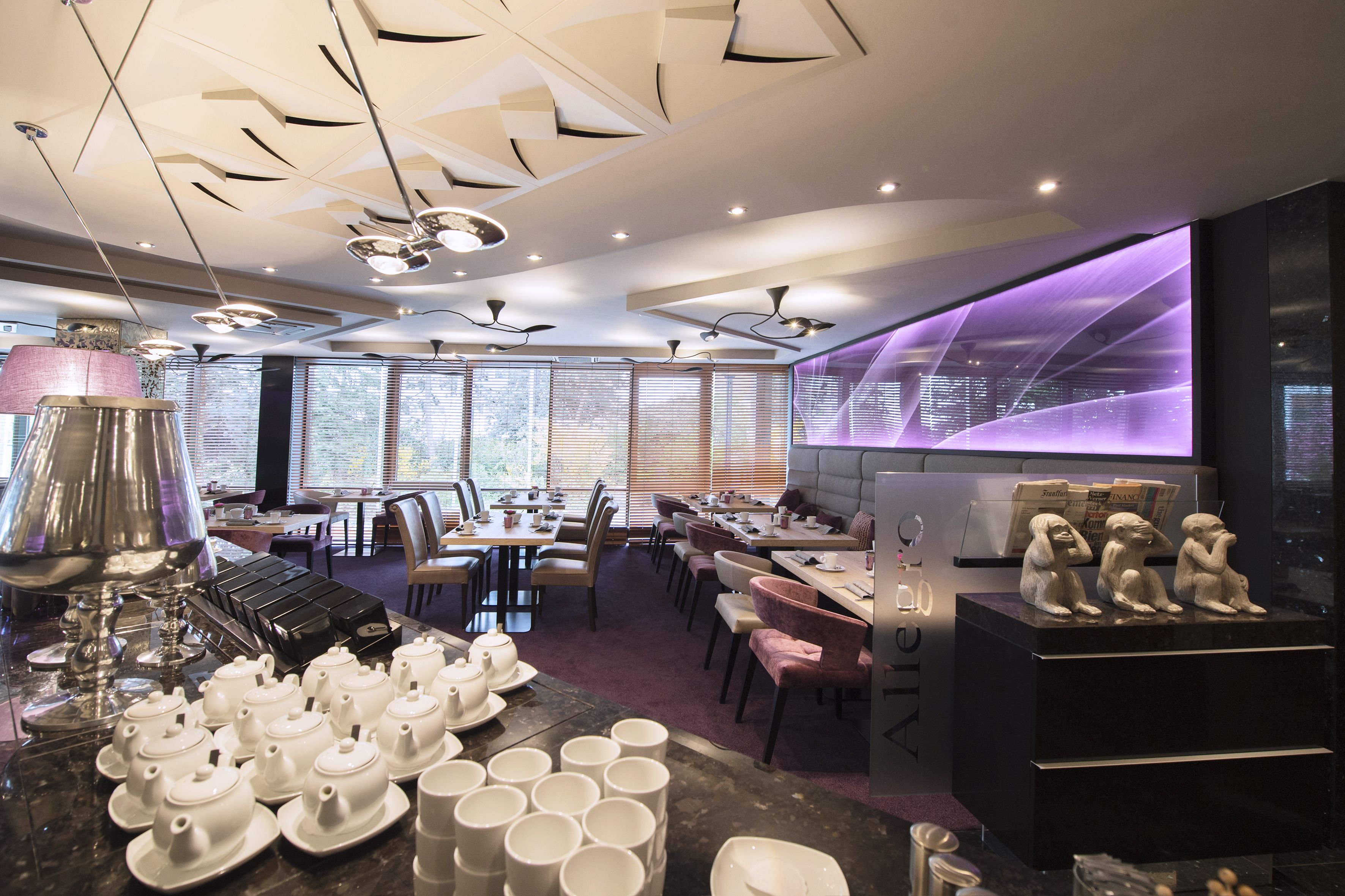 Ein modernes Restaurant mit Tischen, Stühlen und einer Bar.