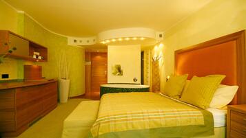 Una habitación de hotel con cama, mesita de noche y cómoda de madera.