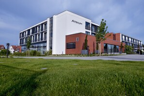 A modern building with a white facade and the name 'Atrium' on the side.