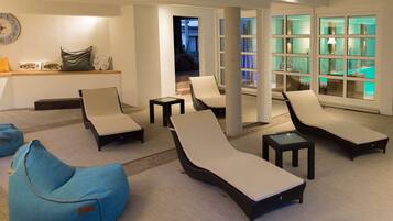 Relax in a spacious room with lounge chairs, a bean bag chair, and a large window offering a view of the outdoor area.