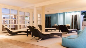 Una piscina techada, sillones reclinables de piscina