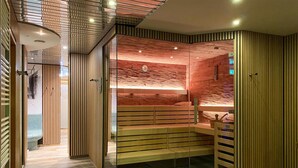 Un spa moderne dot é d’un banc en bois, d’une cloison en verre et d’un mur au motif texturé.