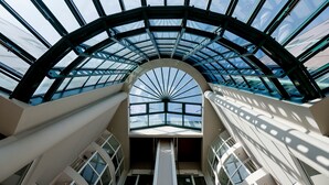 Ein zeitgemäßes Atrium mit Glasdach und einer zentralen Treppe.