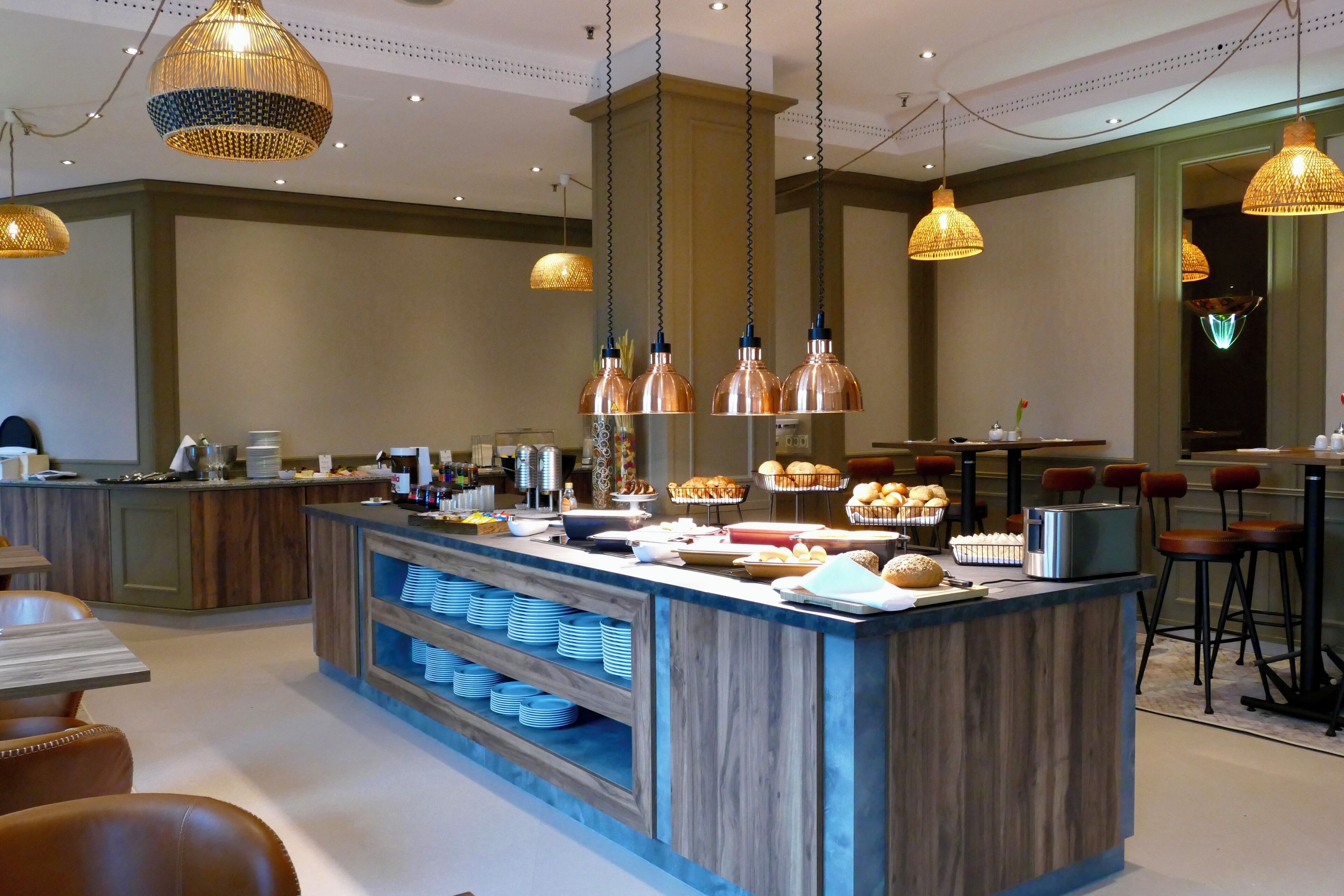 A modern hotel lobby with a central bar area, seating, and decorative lighting.