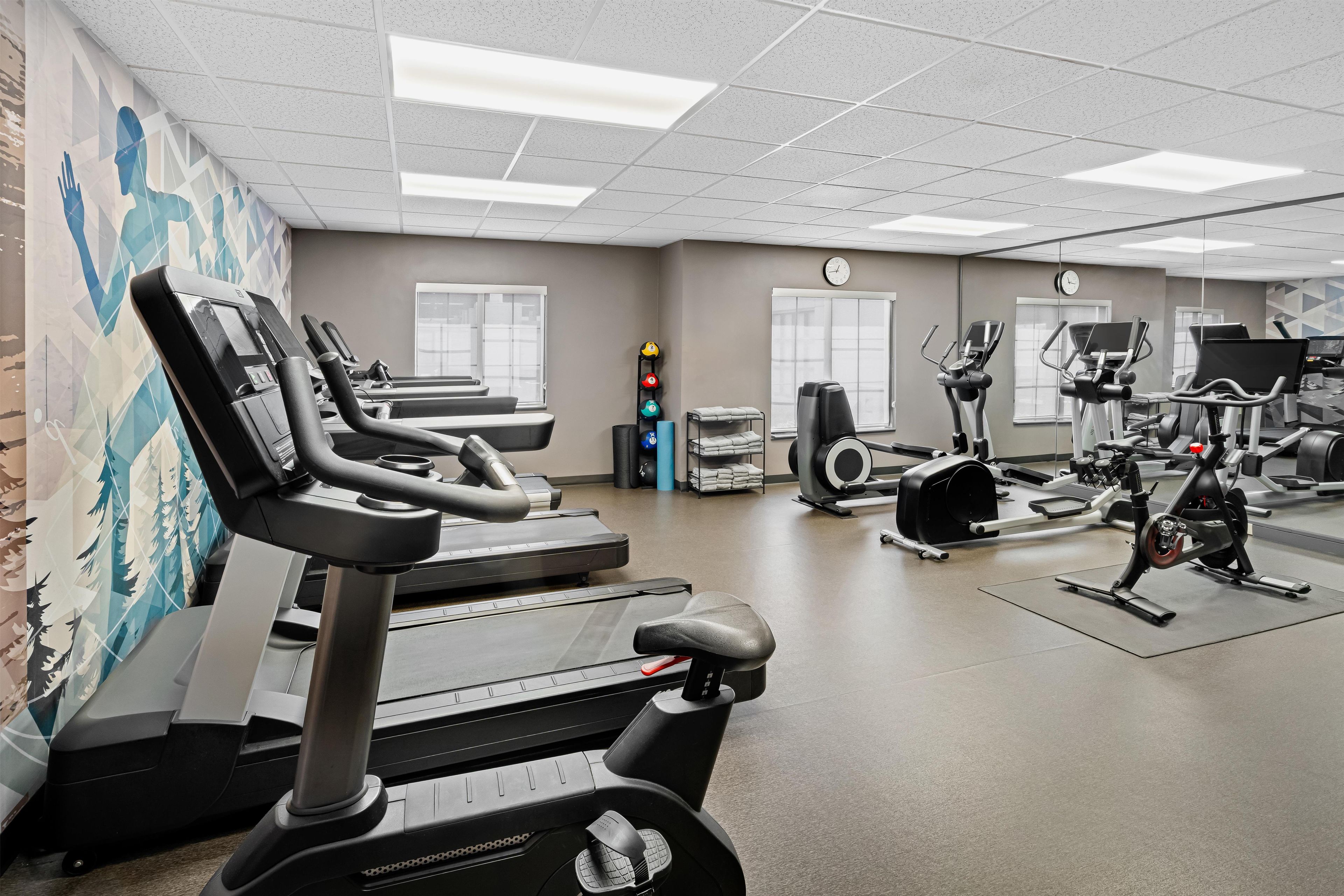 A gym with treadmills, elliptical machines, and weight equipment.