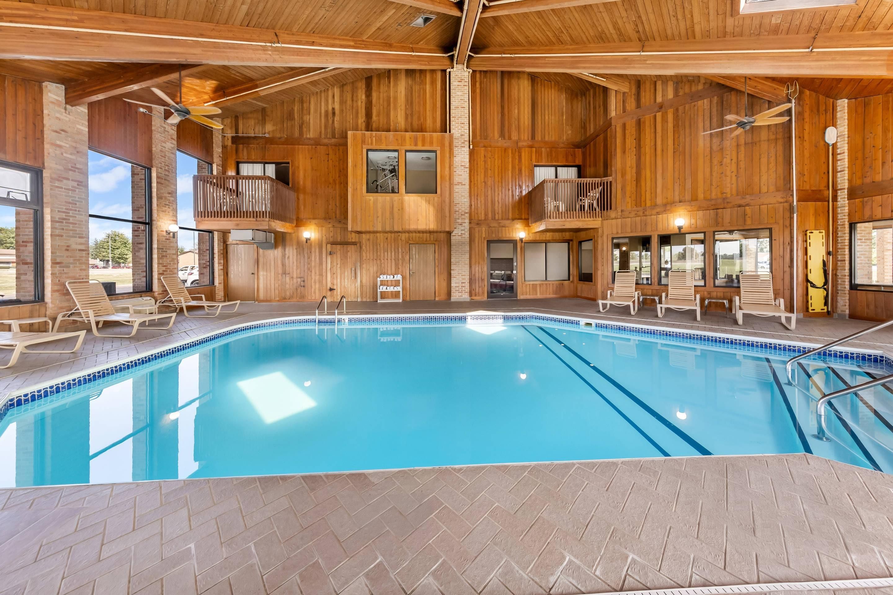 A large indoor swimming pool with wooden walls and multiple levels of balconies.