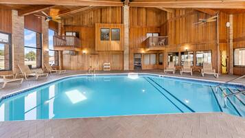 Una gran piscina interior con paredes de madera y varios niveles de balcones.