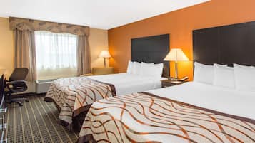A hotel room with two beds, a desk, a chair, and a window with curtains.