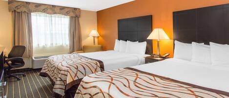 A hotel room with two beds, a desk, a chair, and a window with curtains.