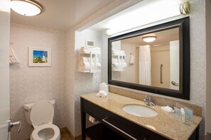 A bathroom with a toilet, sink, and mirror. There are towels and toiletries on the counter. - Hampton Inn Pensacola-Airport (Cordova Mall Area) (Pensacola)