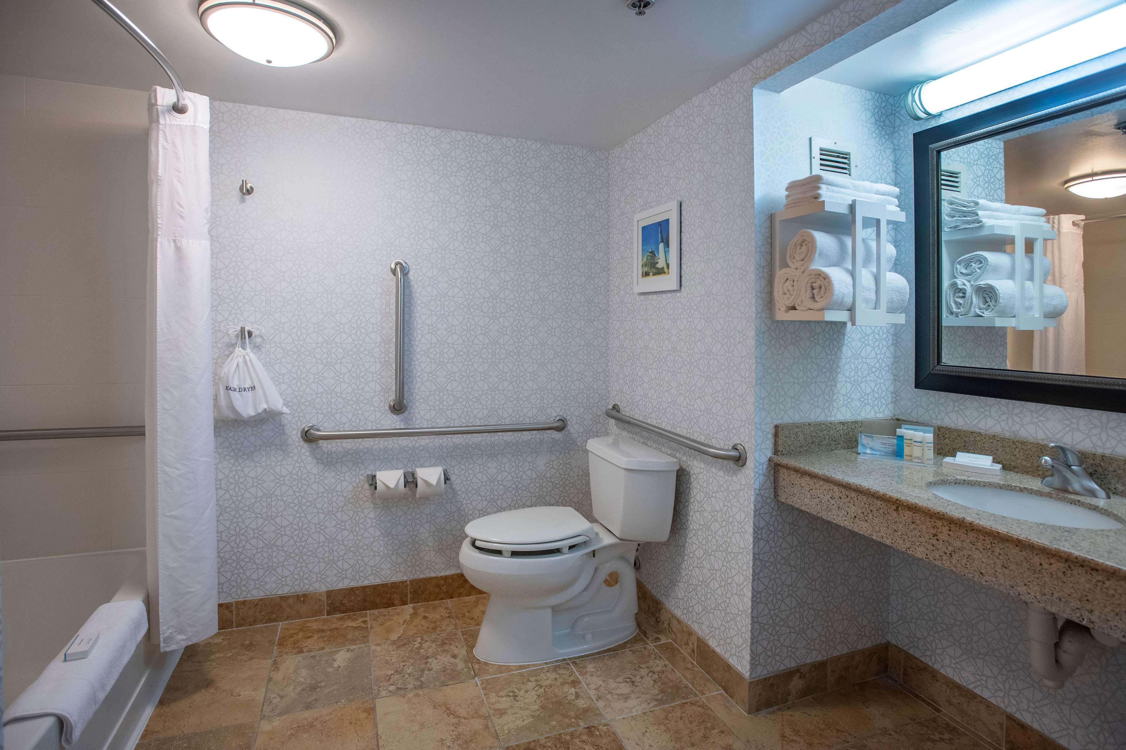 A bathroom with a toilet, shower, and sink.