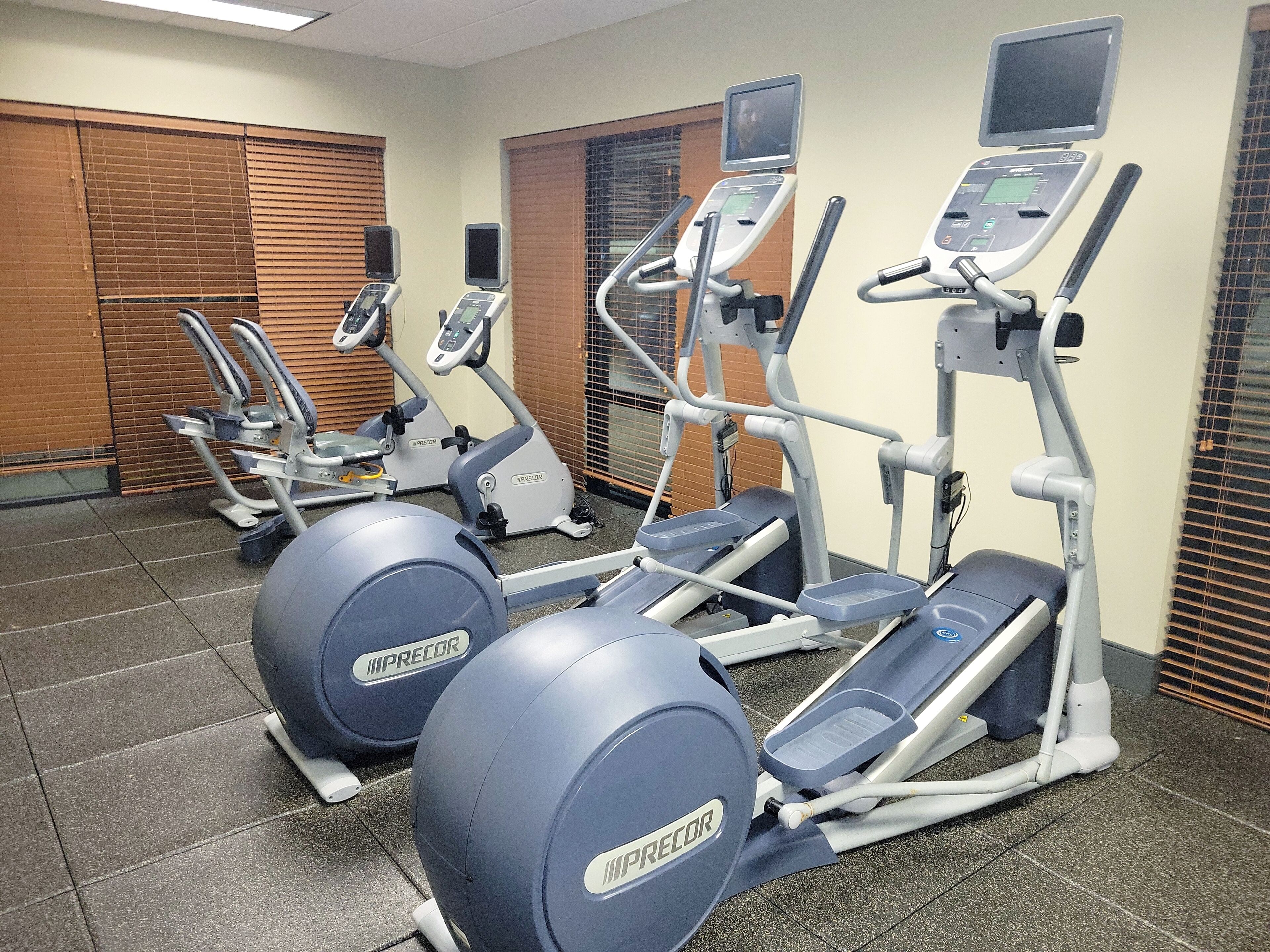 Ein Fitnessstudio mit Laufbändern, Crosstrainern und Ergometer.