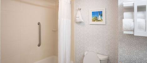 A bathroom with a shower, toilet, and a towel rack.