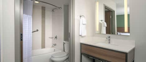 Un bagno moderno con vasca, WC e mobile lavabo con specchio.