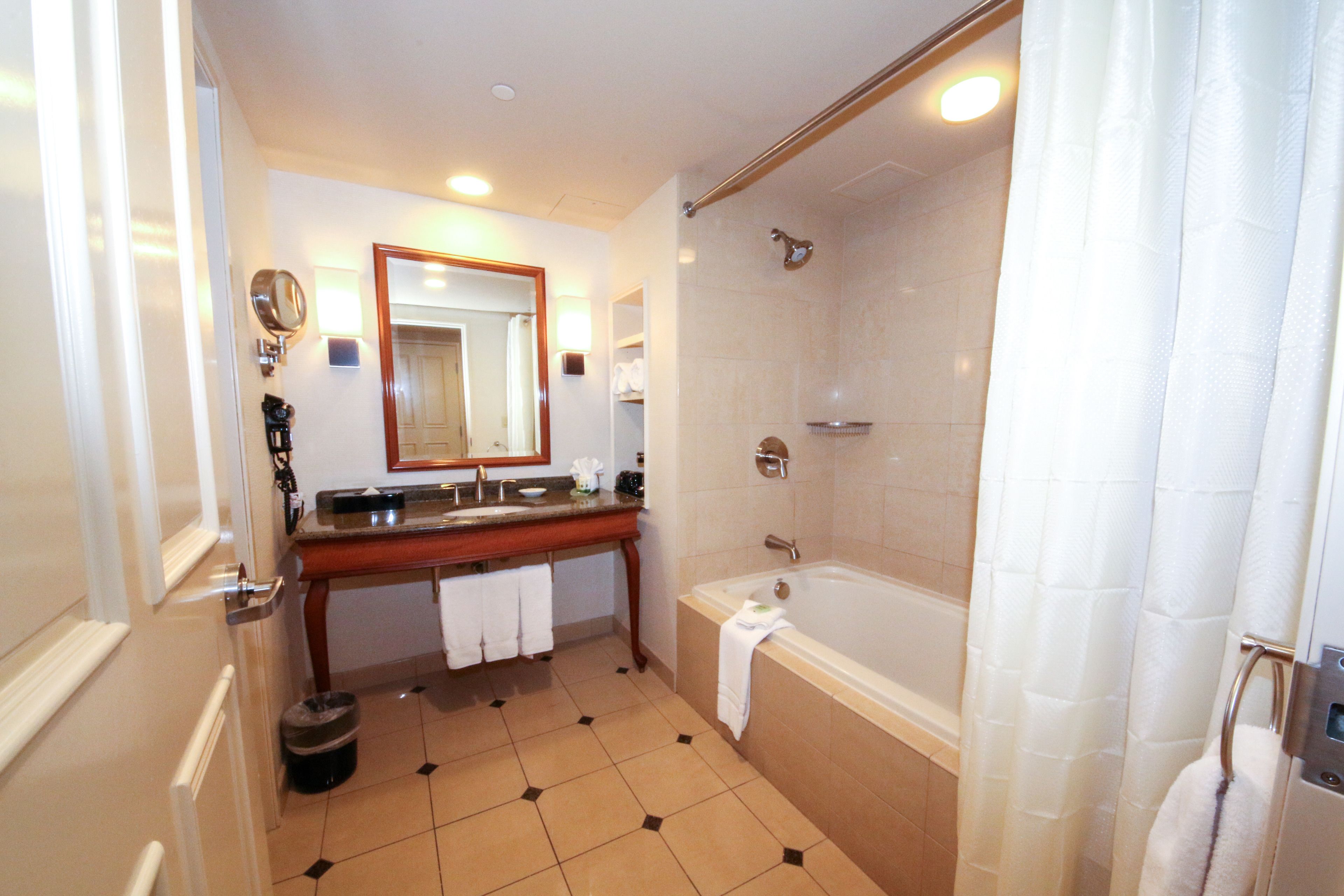 A bathroom with a double sink, a bathtub, and a shower.