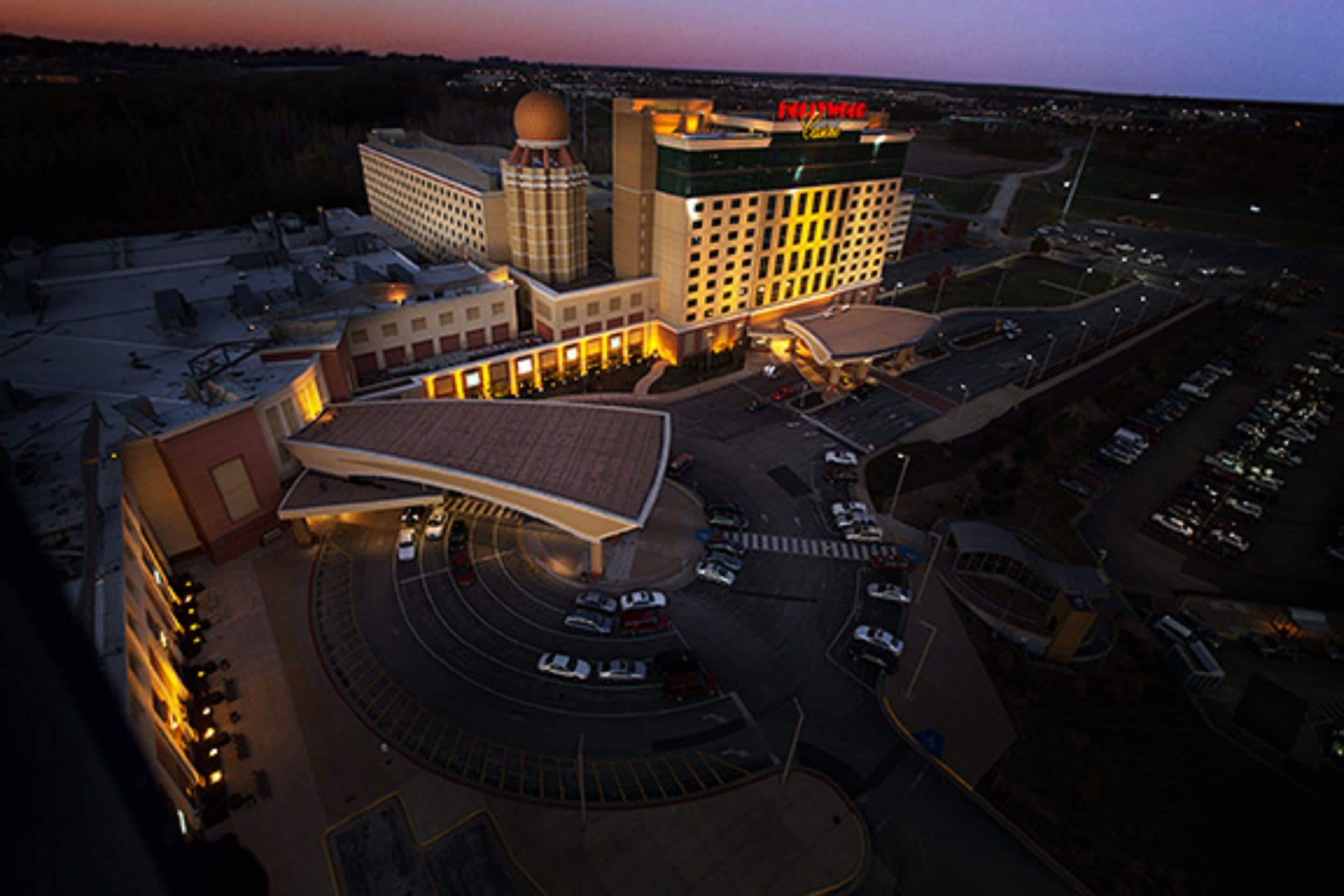 An aerial view of a hotel with a large parking lot, a central building with a dome, and multiple smaller structures around it.