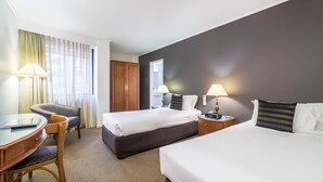 A hotel room with two beds, a desk with a chair, and two bedside tables with lamps. - Great Southern Hotel Brisbane (Brisbane)