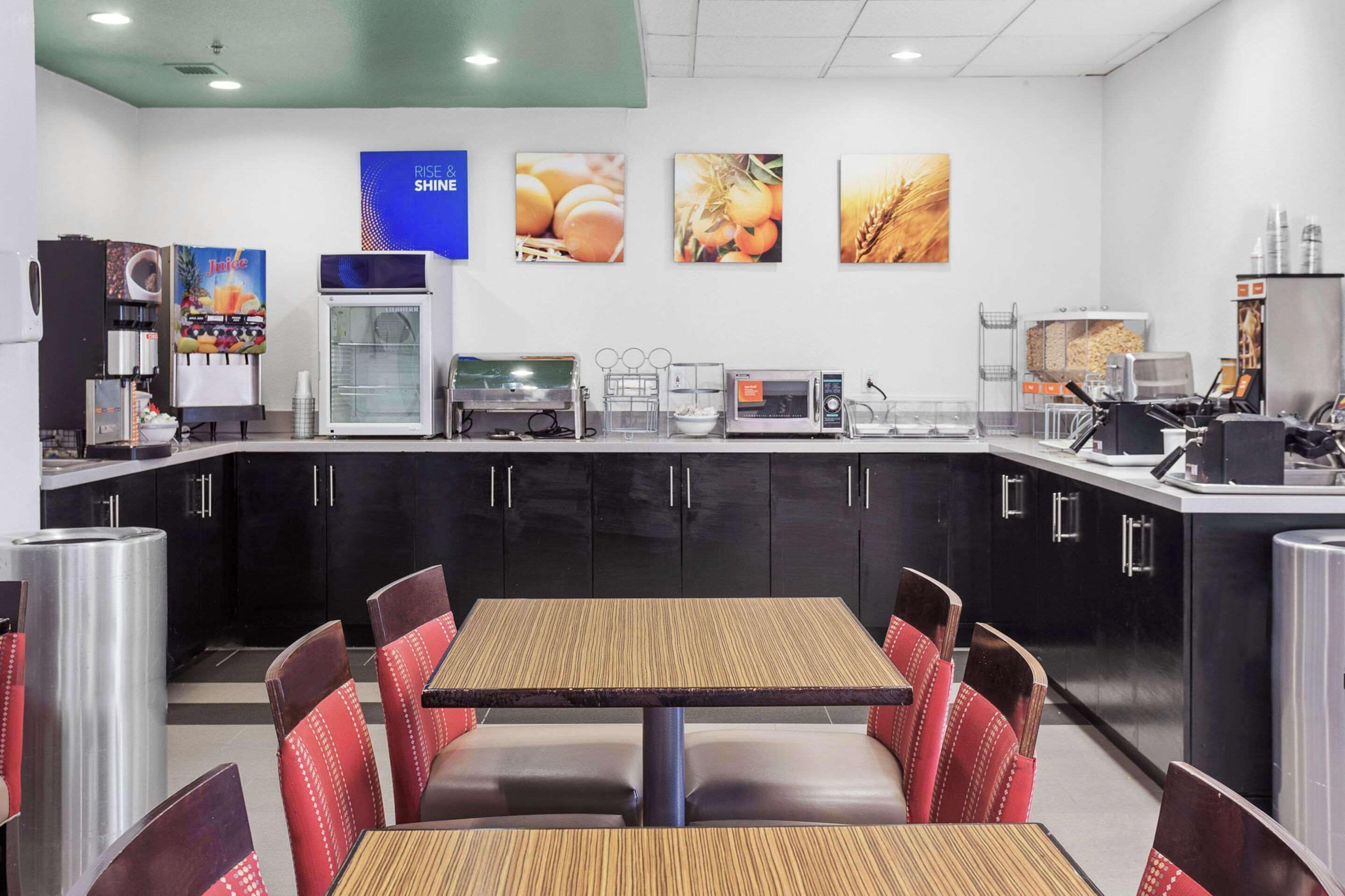 A restaurant with a counter, seating area, and kitchen equipment.