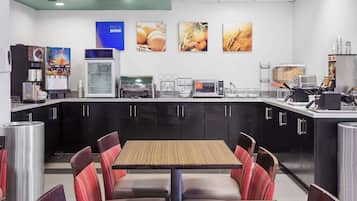 A restaurant with a counter, seating area, and kitchen equipment.