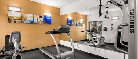 A hotel fitness center with treadmills, an elliptical, and a rowing machine.