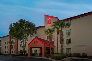 Un hotel con techo rojo y un letrero que dice 'Red Roof Plus'.