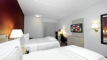 Habitación de hotel con dos camas, un escritorio, una silla, un televisor y un espejo.