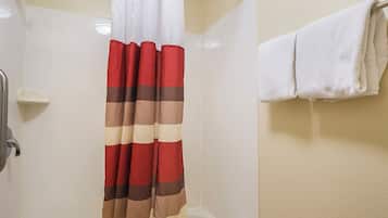 A bathroom with a shower curtain, a bathtub, and a towel rack.