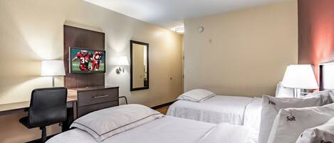 A hotel room with two beds, a desk, a chair, a TV, and a mirror.