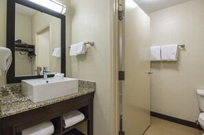 A bathroom with a sink, mirror, towel rack, and toilet.