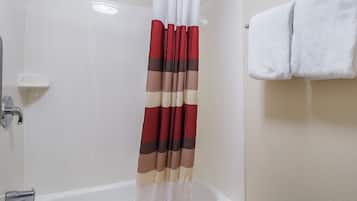 A bathroom with a bathtub, a shower curtain, and a towel rack.