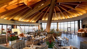 Un restaurant ampli amb sostres alts i grans finestres que ofereixen vista a la muntanya.